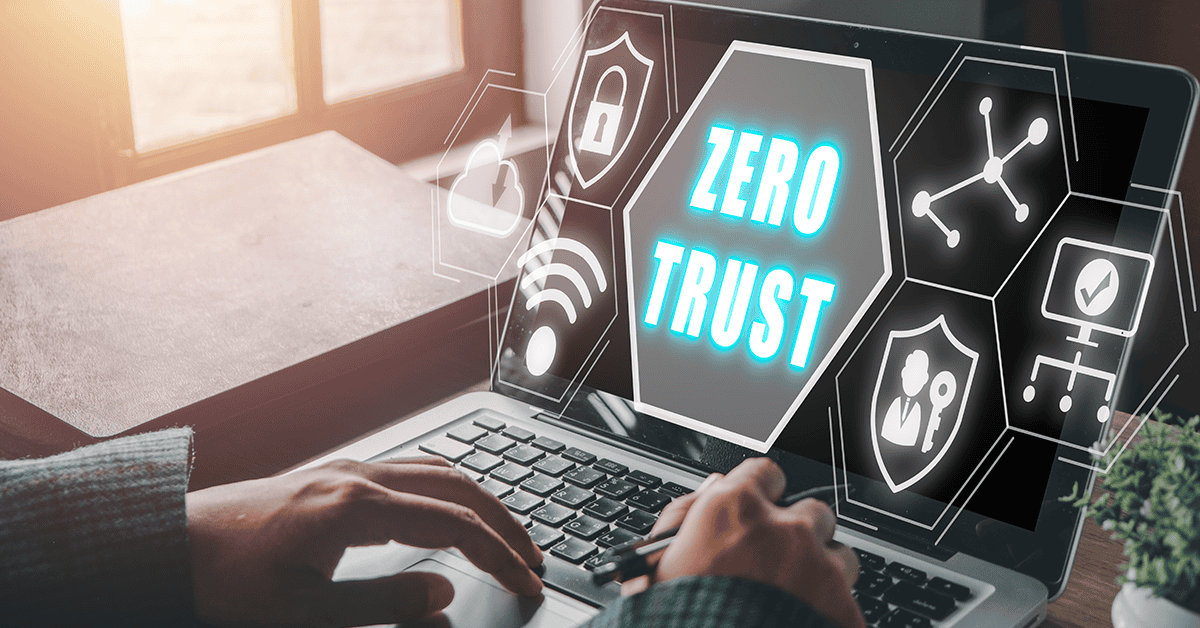Zero Trust: What is It and How Does It Affect the US Air Force - top government contractors a cropped view of hands typing on a laptop with the phrase “Zero Trust” surrounded by different icons