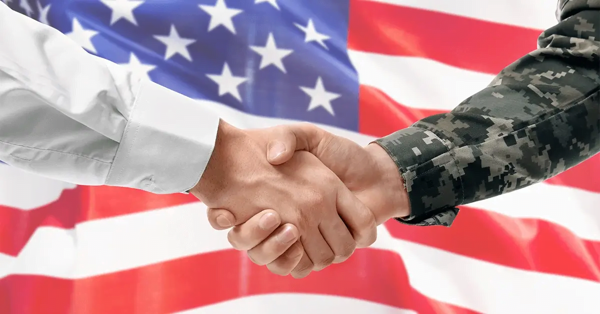 Federal News: Exploring the Trends and Innovations in Government Contracting - top government contractors A soldier and civilian shaking hands with the USA flag in the background